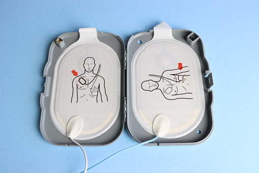 Defibrillator electrodes in the case in a light blue background