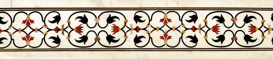 Detail of pacchi kari, pietra dura or stone inlay on Taj Mahal, Agra, India. Floral border inlaid in white marble. UNESCO World Heritage Site.