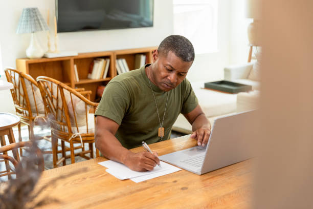 istock Mature male veteran uses laptop while working on home budget 1583459372