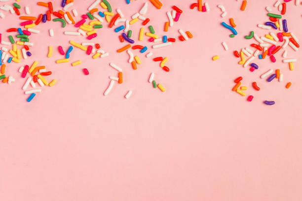istock Colorful sugar sprinkles on pink background with copy space 1583472447