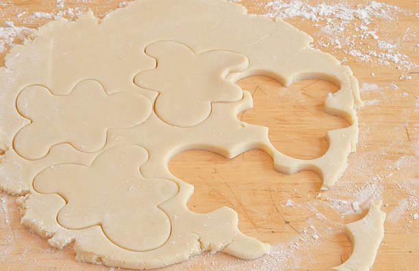 istock Gingerbread boys cut from cookie dough on a floured surface 158348641