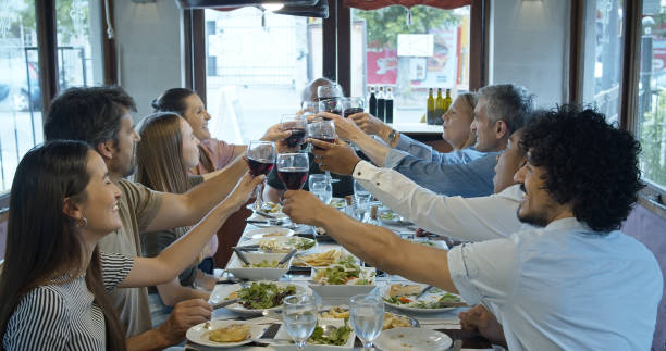 istock Large Diverse Family Toasting and Drinking at Restaurant Meal 1583502796