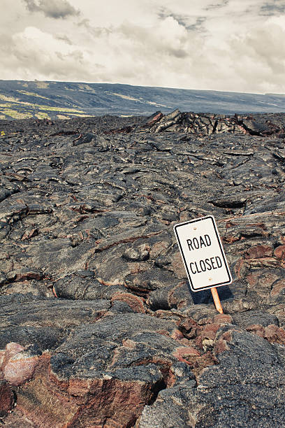 istock Road closed sign and highway damaged by lava 158354673
