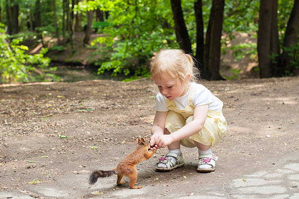 istock Little girl feeding squirrel 158356266
