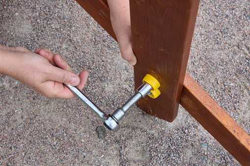 Ratchet socket wrench is used to tighten bolt during outdoor furniture assembly by outdoor.