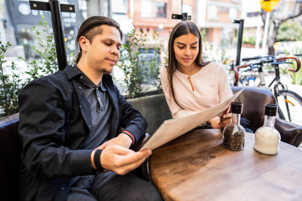 istock Friends reading menu at a coffee shop 1583575472