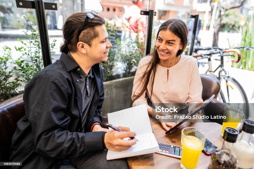 Happy coworkers working at a coffee shop 16-17 Years Stock Photo