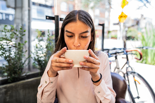 Young woman drinking coffee at a coffee shop