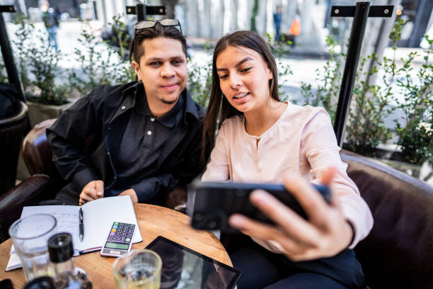 istock Coworkers taking a selfie or filming using mobile phone at a coffee shop 1583576524