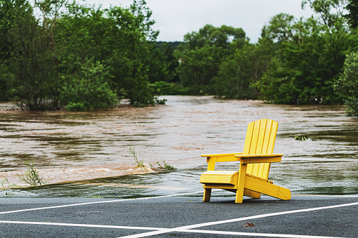 A sunchair sits at the edge of a river following record breaking rainfall.