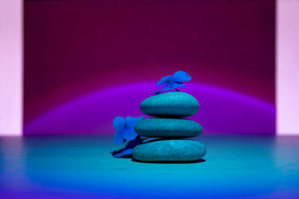 pila de guijarros con flor, concepto tranquilo de relajación. fondo ultravioleta. - alternative therapy stone zen like nature fotografías e imágenes de stock