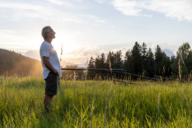 Senior man walks through mountain meadow