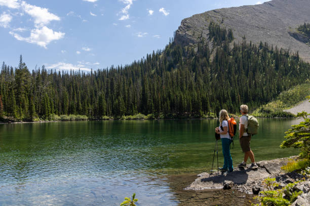 istock Senior couple explore alpine lake shoreline 1583633947