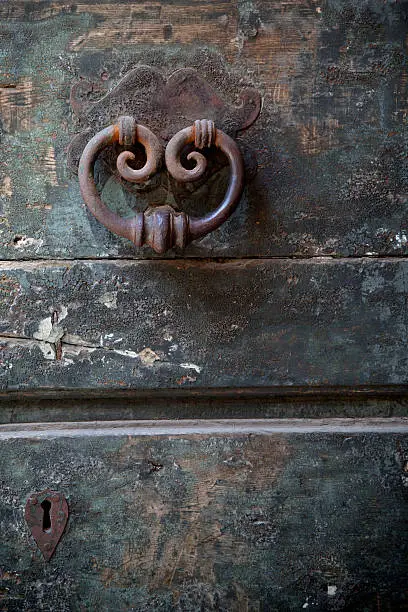 antique door-knocker on old door with keyhole