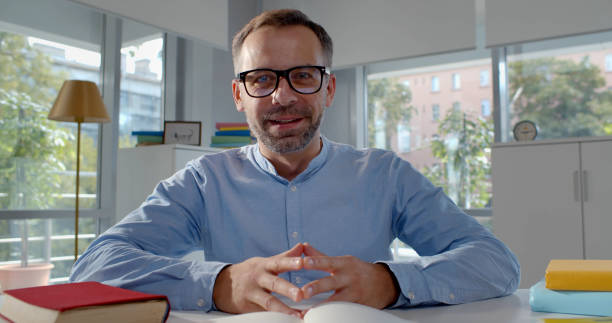 istock Mature tutor in eyeglasses teaching online from home 1583704337