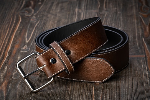Brown leather belt fastened with buckle, isolated on white, clipping path included
