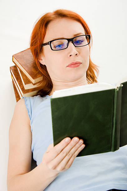 istock Young beautiful woman with red hair reading book 158370871