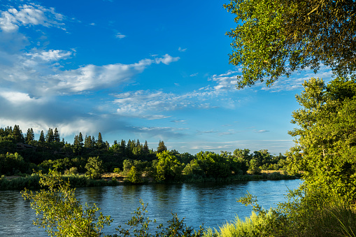 Wide shore view of Sacramento River with clouds in the background.\n\nTaken along the shore of the Sacramento River, River Bend Park, Sacramento, California, USA