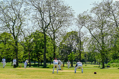London, UK, 27 May 2023: Cricket Batting Bowler Action Cricket game  in London park game batsman bowler action photo