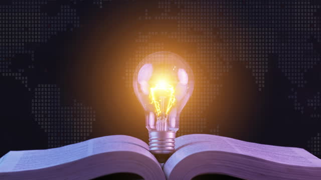 Close up of glowing light bulb on the open book. Inspiring from reading books and education, Innovations, self-learning, knowledge and searching for new ideas. Thinking and creative concept.