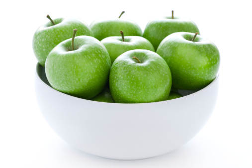 fresh green granny smith apples in a white bowl