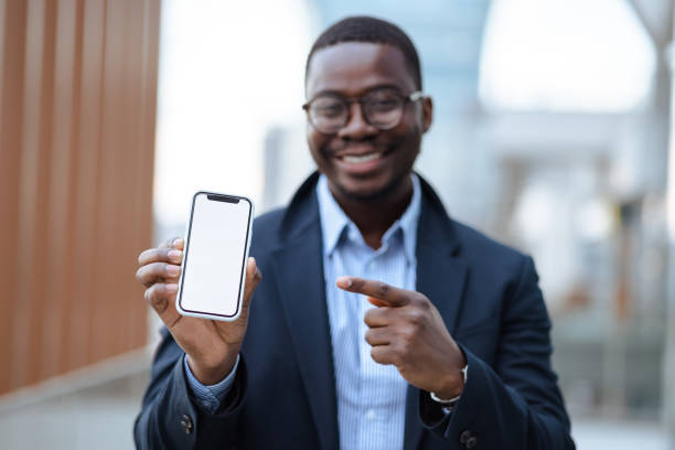 istock Young African American man showing smart phone with a blank screen 1583795150