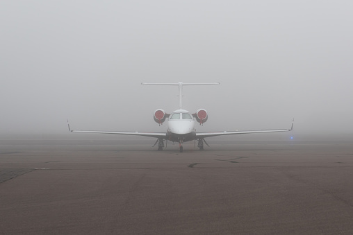 Embraer business jet parked on the foggy ramp at Phoenix Deer Valley Airport.