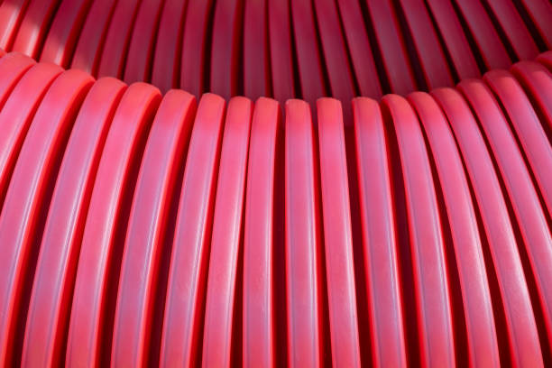 istock red corrugated PVC pipe cover protection for electric cables.  macro filled frame. Construction site with Material infrastructure installation. 1583820260