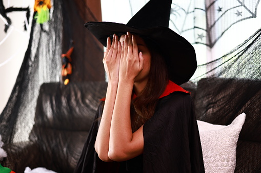 Halloween Witch  young woman  Close your eyes and play peek-a-boo