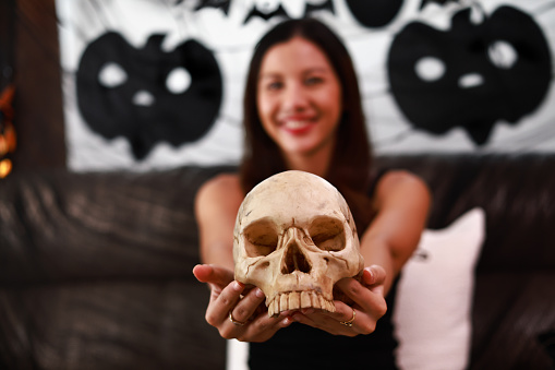 Pretty women giving you  a  skull  on Halloween holidays