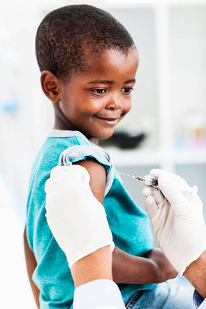 istock Young African boy smiling while getting a vaccination in arm 158385990