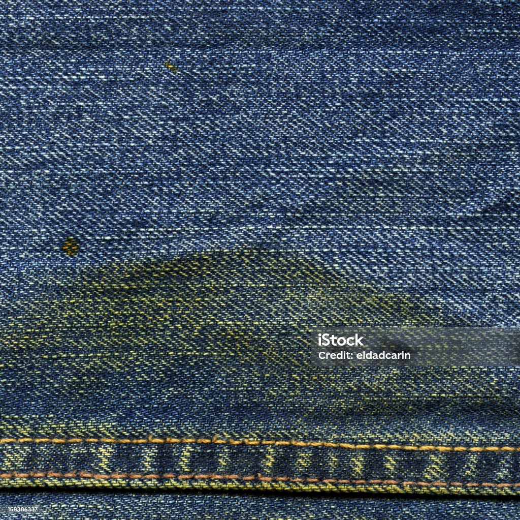 Denim Fabric Texture - with Seam and Stain XXXXL High resolution scan of blue denim fabric, with a large yellow stain and horizontal seam crossing. Abstract Stock Photo