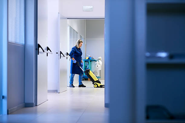 Women at workplace, professional female cleaner washing floor in office stock photo