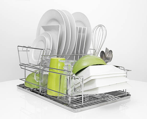 Bright dishes drying on metal dish rack stock photo