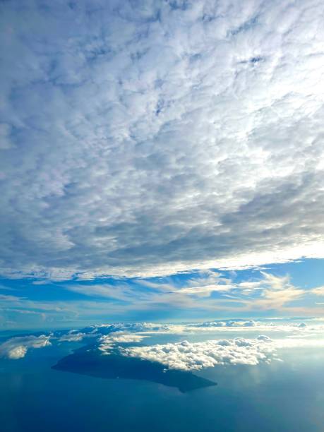 istock Clouds, blue skies, ocean and an island 1583931094