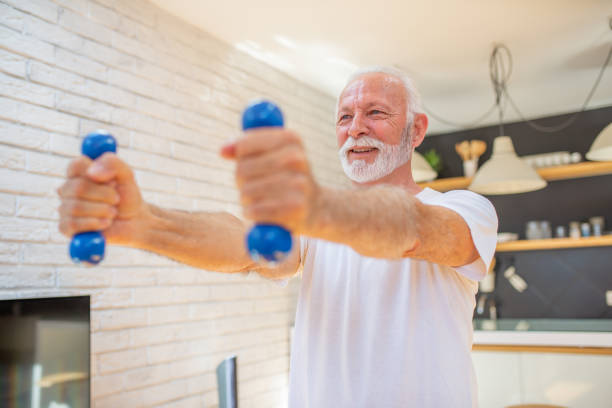 istock Senior man at home keeping fit by exercising 1583944491