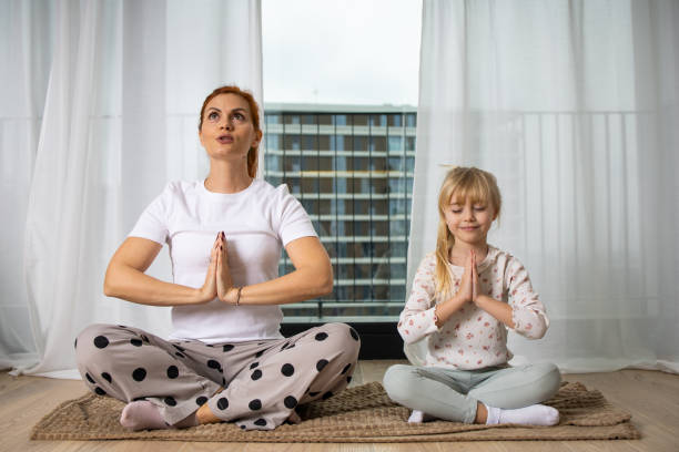 istock Mother and daughter doing yoga 1583950005