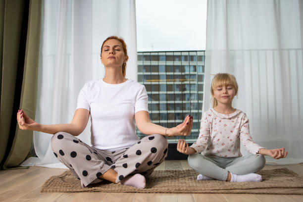 istock Mother and daughter exercising yoga 1583950006
