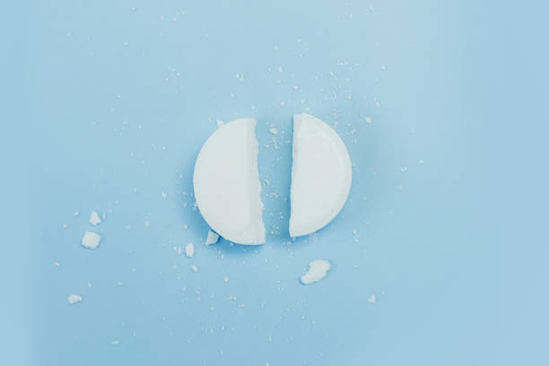istock a white round tablet was cut into 2 equal parts. Pill broken on half. Pharmacy medicament concept. 1583958121