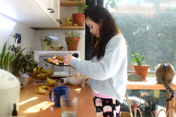 istock girl in the kitchen eating fruit 1583985790