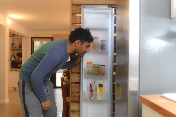 istock man keeping groceries in the fridge 1583988411