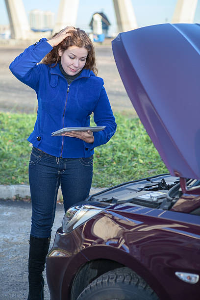 istock Woman in thought standing before car opened hood 158398900