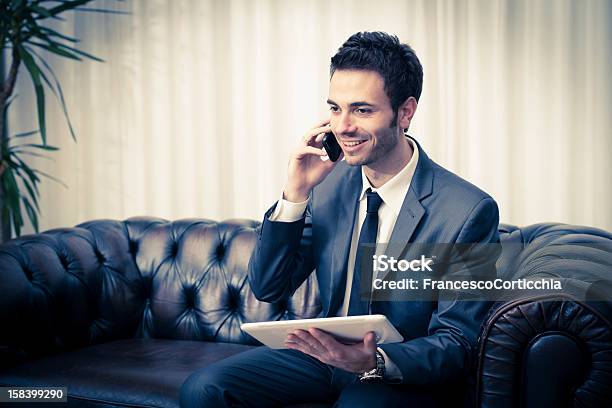 Photo libre de droit de Jeune Homme Daffaires Avec Tablette Et Téléphone Intelligent banque d'images et plus d'images libres de droit de Adulte