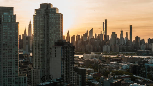 hunters point, long island city, queens, mit blick auf den sonnenuntergang von manhattan über den east river. - queens stock-fotos und bilder