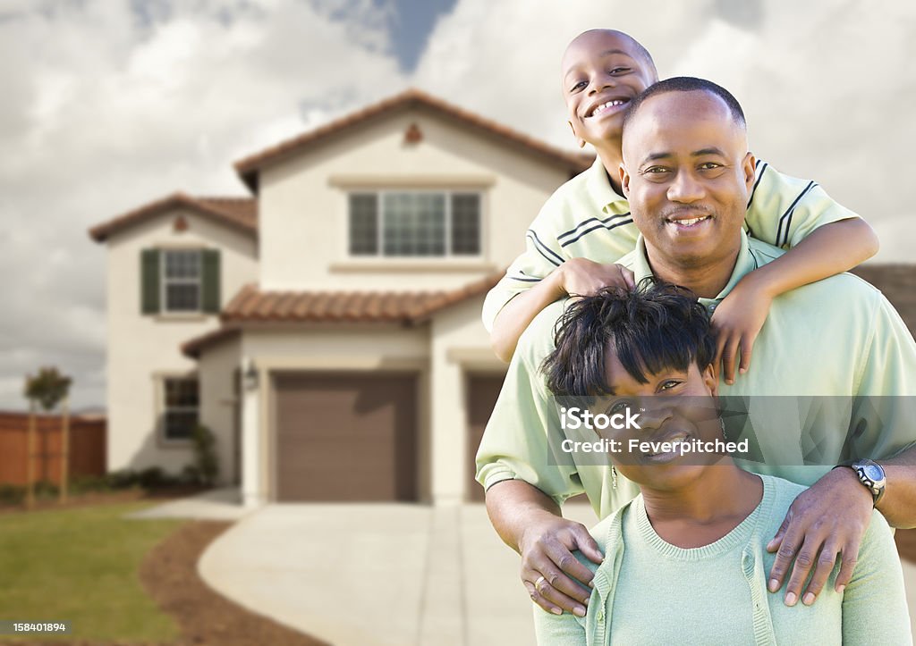 Attractive African American Family in Front of Home Attractive African American Family in Front of Beautiful House. House Stock Photo