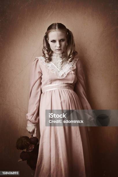 Spooky Victiorian Girl Holding Doll Foto de stock y más banco de imágenes de Embrujado - Embrujado, Estilo victoriano, Vestido