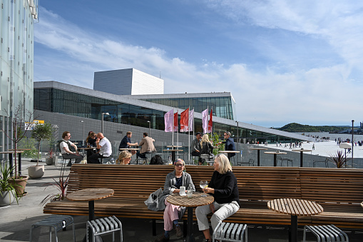 Oslo, Norway, July 5, 2023 - The Centropa restaurant, café and rooftop bar at Oslo's new main library, Deichman Bjørvik in the background the Oslo Opera House .