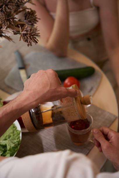 istock Man pours tea from a teapot in the kitchen at the table 1584093281