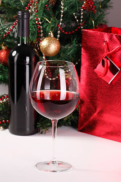 red wine, christmas tree and bag with gift stock photo