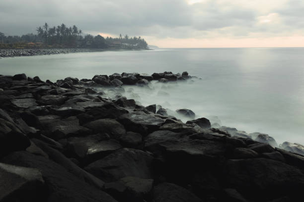 istock Mist and ocean waves splashing on rocks 1584200747